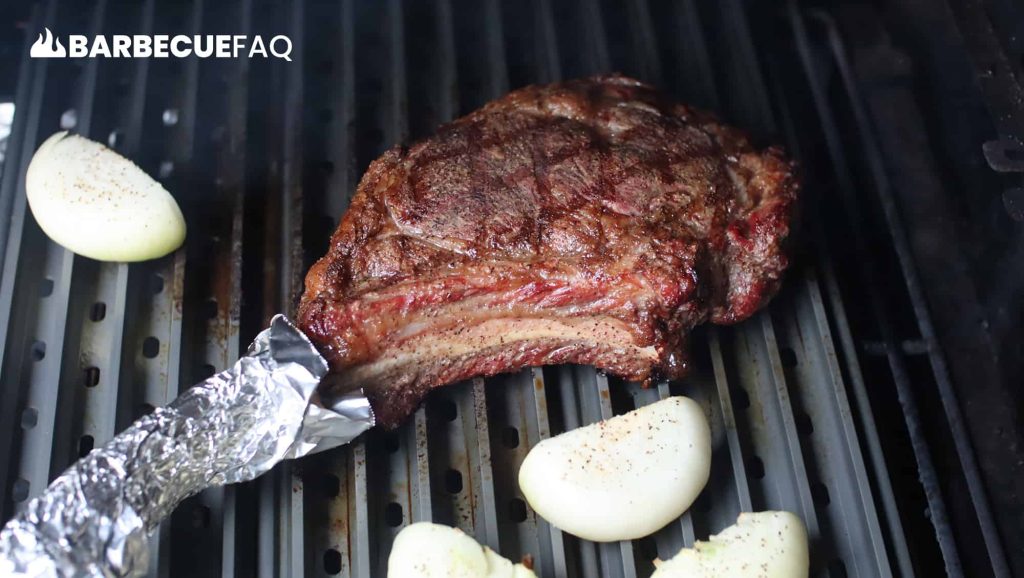 searing tomahawk steak on grill grates in pellet grill