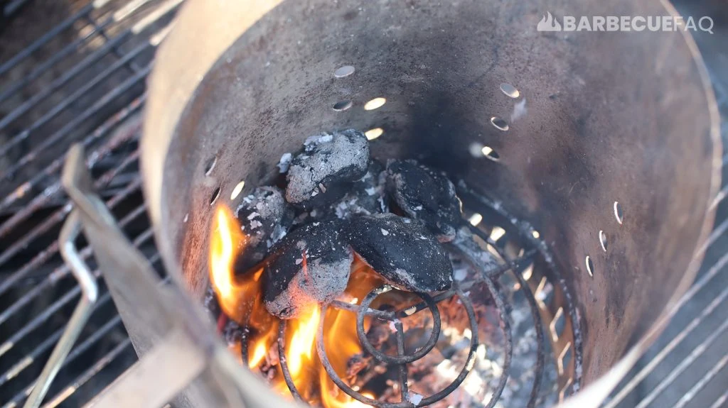 soaked charcoal lighting in a charcoal chimney