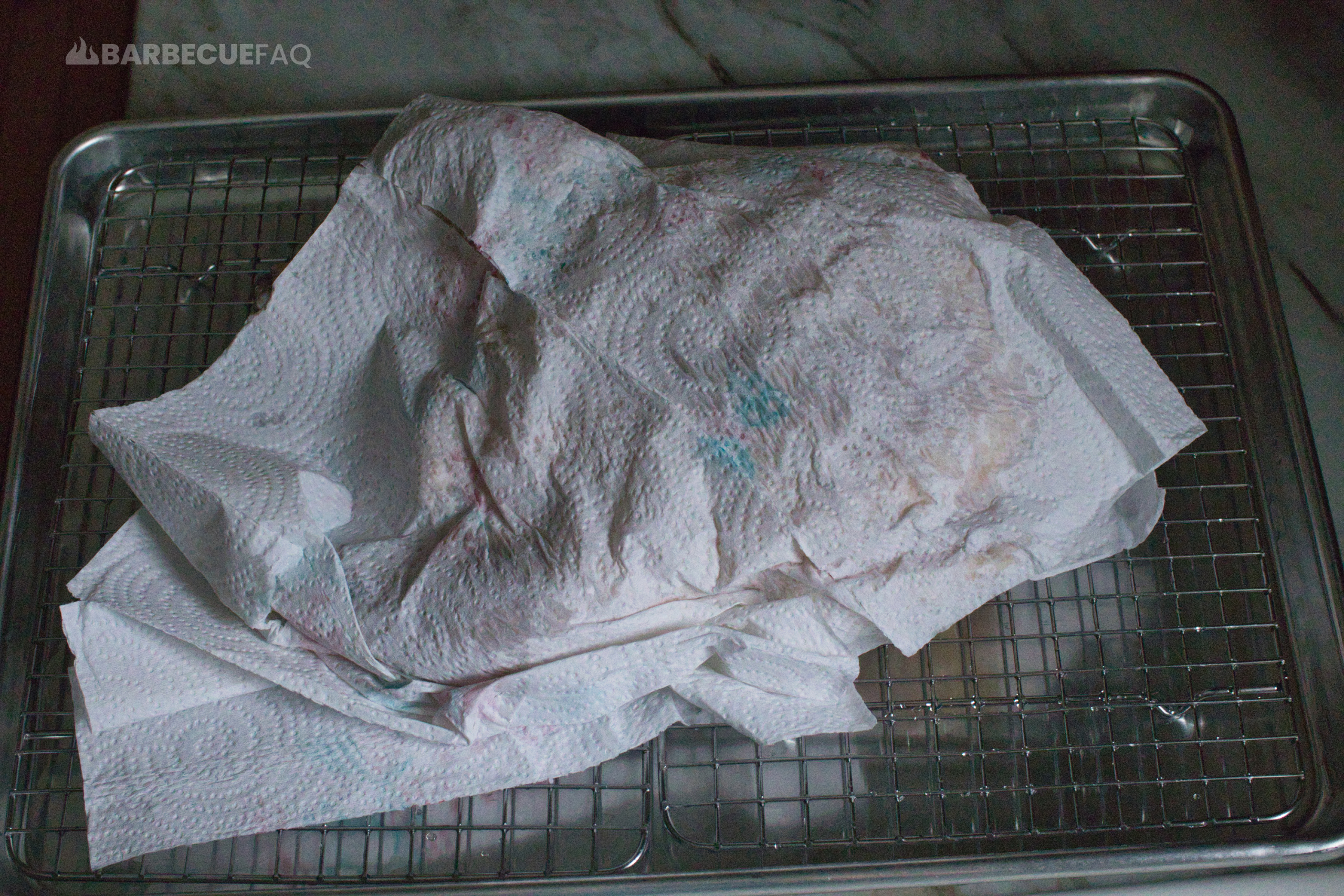 pat drying chicken with paper towels