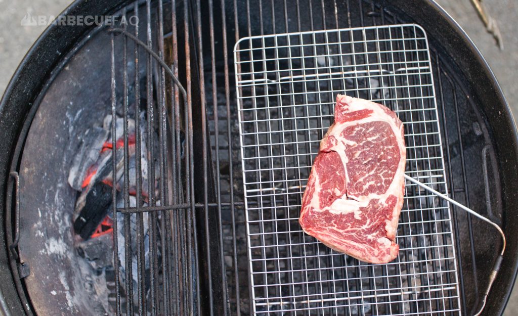 steak in cool zone of grill