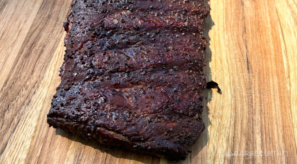 smoked ribs that have a dark bark and are ready to be wrapped