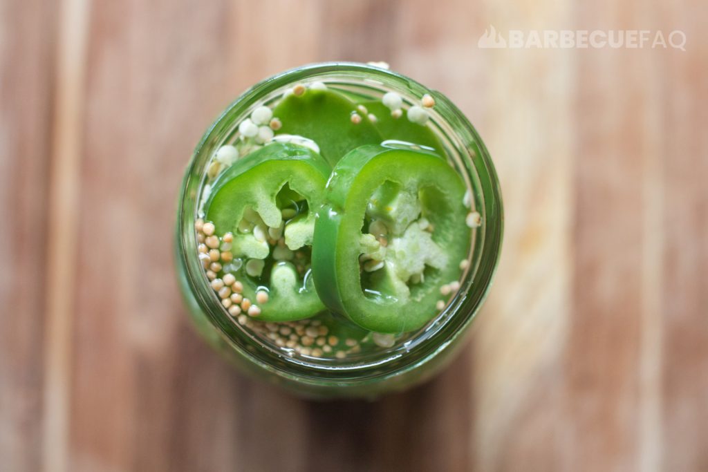 jalapenos in mason jar with pickling liquid