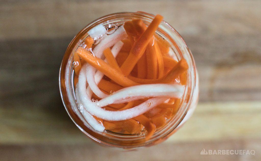 pickled daikon and carrots with brine liquid top down view