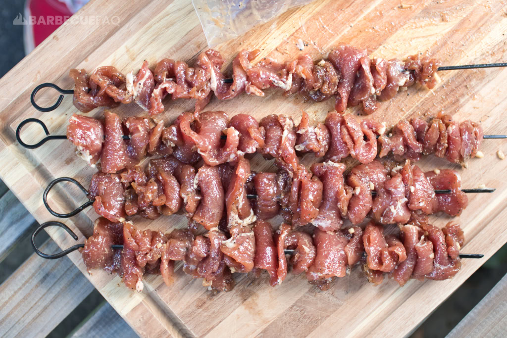 putting pork on skewer