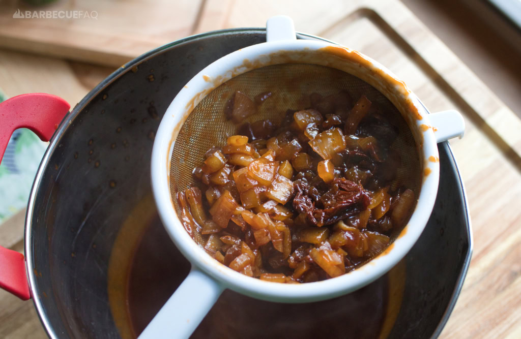 straining chipotles and onions from bbq sauce