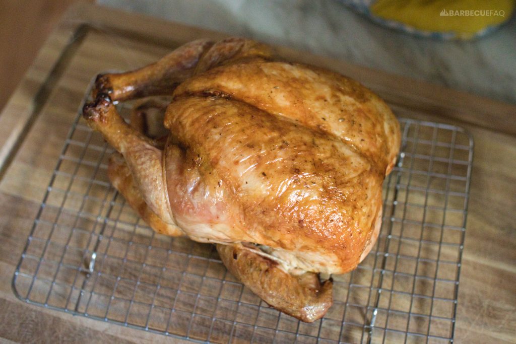 whole roast chicken resting on a cutting board