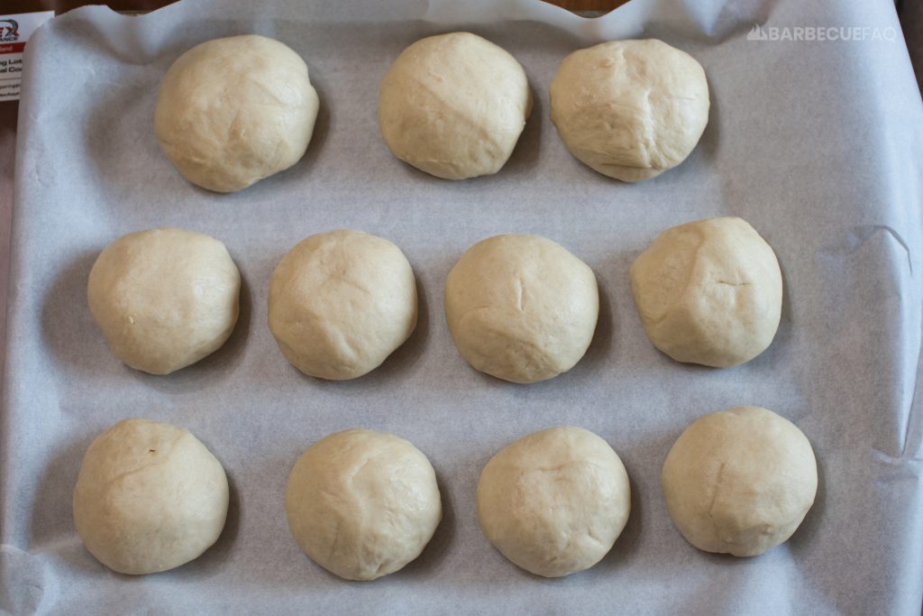 dough rolls on parchment paper on baking sheet